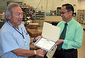 Ron Fujii (left) receives a Retirement Commendation from APWU San Jose Area Local president Ed Peralta. The 42-year postal veteran is now a member of the union's Retiree Department.