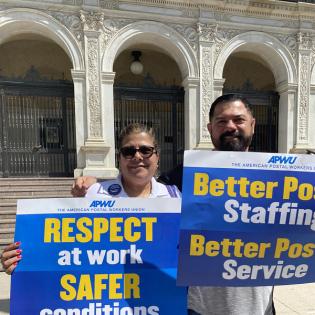 two people hold signs saying respect at work safer conditions