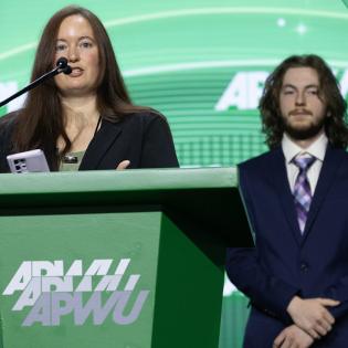 Ashely Cargill and her son, the youngest delegate at APWU convention, speak at the stage