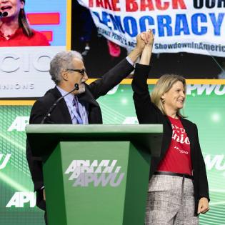 AFL-CIO President Liz Shuler and Mark Dimondstein cheer together at APWU convention stage