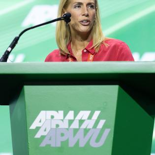 AFA President Sara Nelson speaks at the podium during APWU convention