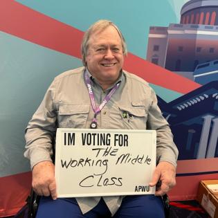 A member holds a sign that says Im voting for the working middle class.