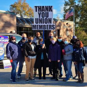 Group of postal workers with "Thank you union members" sign